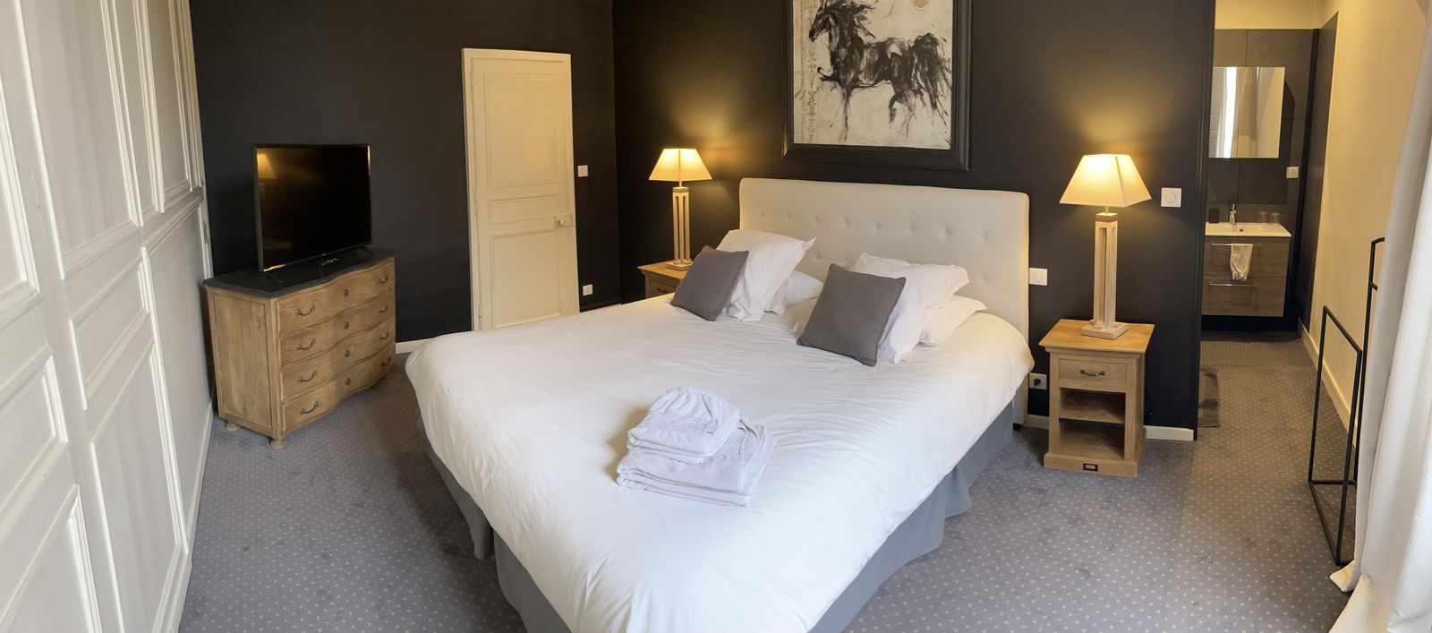 Chambre aux murs sombres, salle de bains attenante