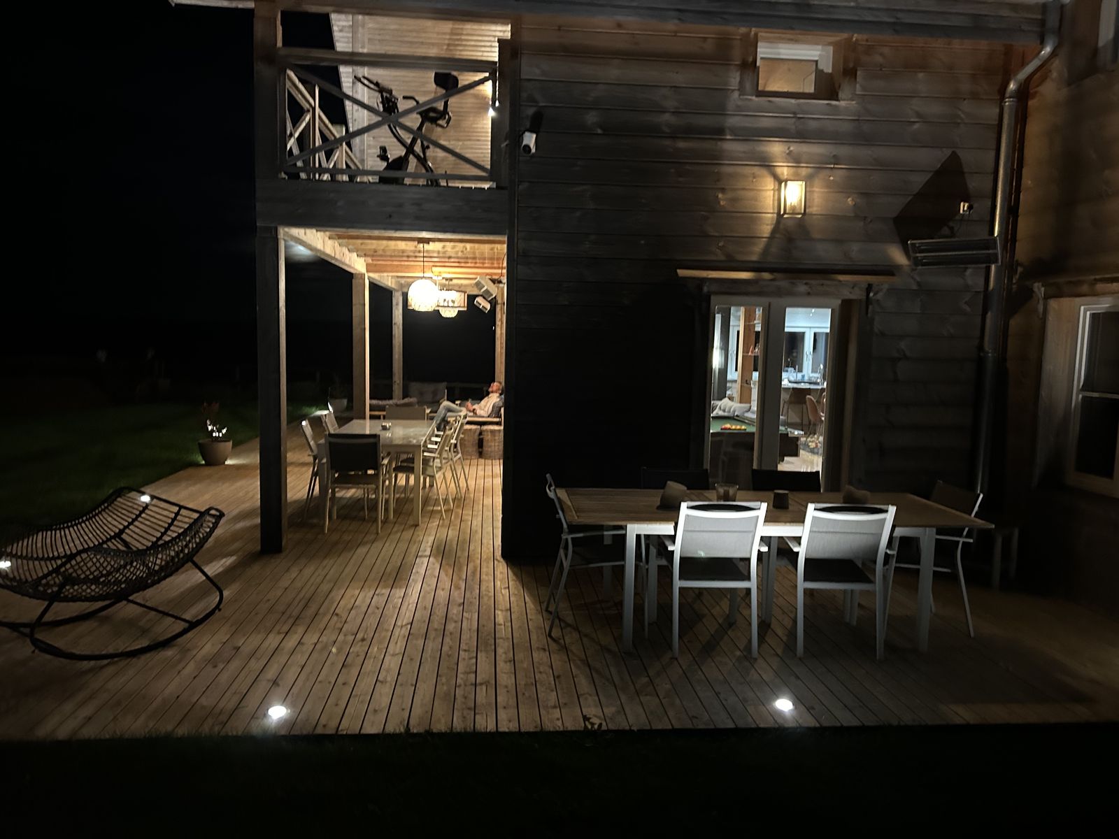 La terrasse couverte et ses deux tablées, le soir