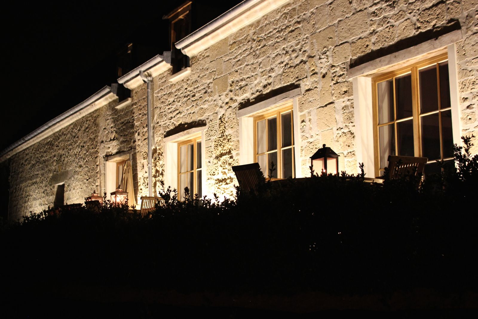 La façade côté terrasse, éclairée à la nuit tombée