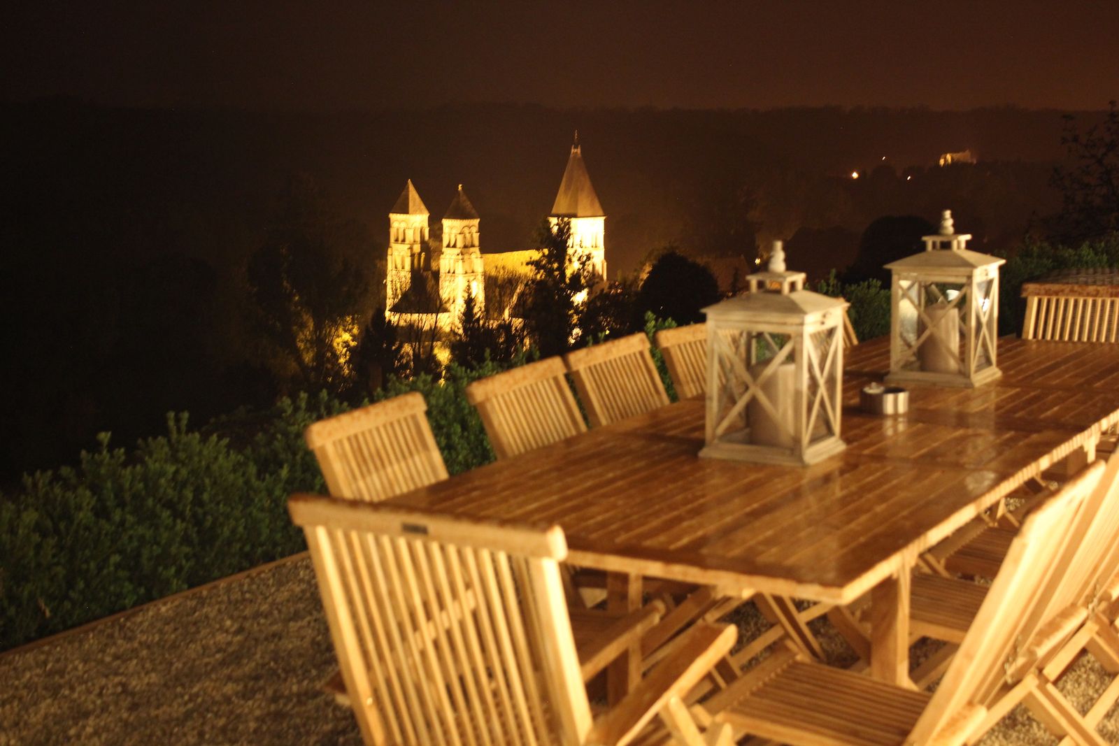 La grande table de la terrasse, l’abbaye illuminée en contrebas