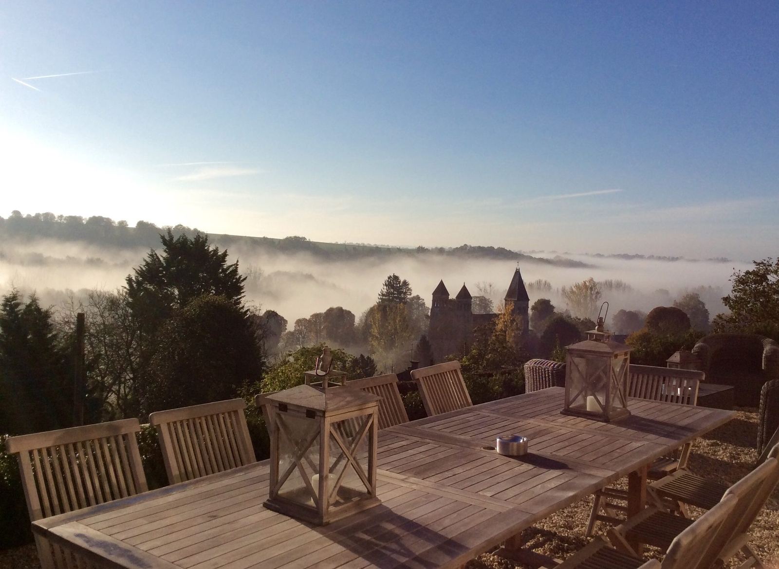 La terrasse de L’Instant La Vue au petit matin, brume sur la vallée et l’abbaye